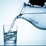 Pour water from a pitcher into a glass